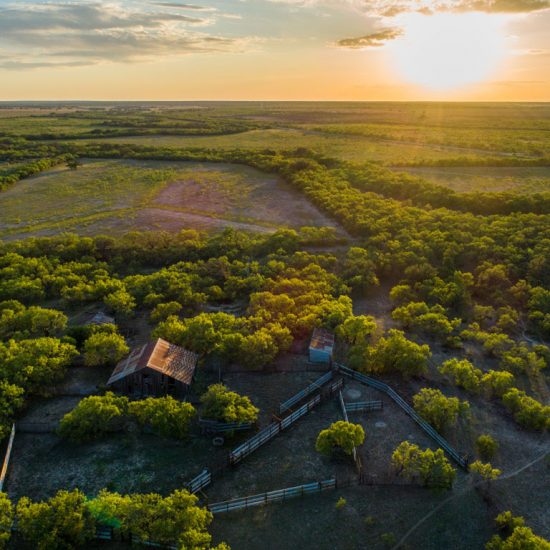 Texas, McCulloch County, aerial view, 2800-acre tract, old barn and pens at sunset